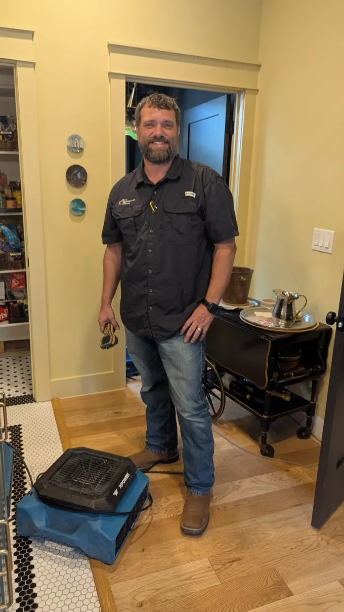 Total Restoration of Texas technician with a drying air mover during an Austin home water damage job